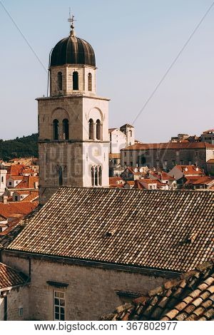 The Bell Tower Of The Franciscan Monastery In Dubrovnik Against The Background Of The Roofs Of The C