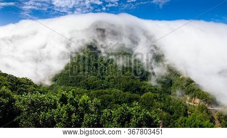 Beautiful Landscape Of Dense Clouds Flowing And Covering High Mountain Peaks On Torpical Island