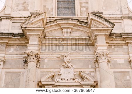Facade Of The Church Of Saint Ignatius In Dubrovnik, Croatia. Statue Of An Angel Above The Entrance 