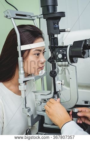 Consultation With An Ophthalmologist. Young Asian Woman And Doctor
