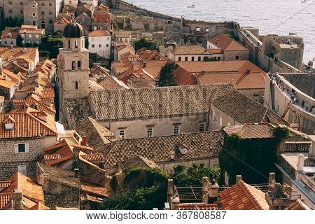 The Bell Tower Of The Franciscan Monastery In Dubrovnik Against The Background Of The Roofs Of The C