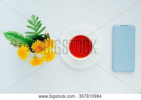 Morning Tea With Light Blue Mobile Phone, Bouquet Of Yellow Spring Dandelion Flowers. Beautifully St