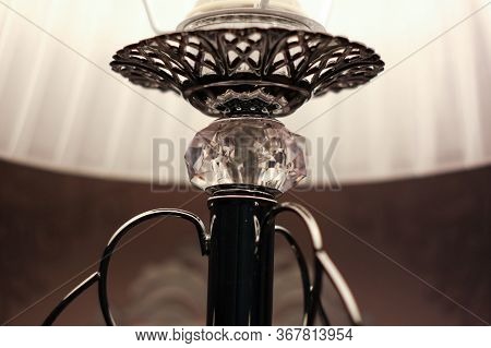 Close Detailed Picture  Of A Bedside Silver Lamp, Which Is Decorated With A Crystal And White Lampsh