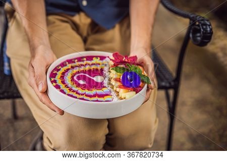 Young Man Having A Mediterranean Breakfast, Eats Healthy Tropical Breakfast, Smoothie Bowl With Trop