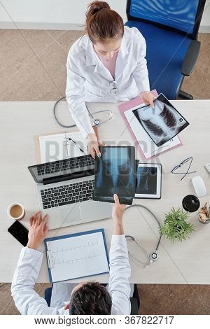 Nurse Giving Lungs X-ray Of Patient To Pulmonologist, View From Above