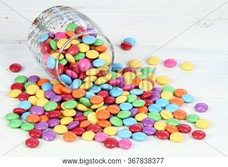 Glass Full Of Colorful And Sweet Smarties.  Chocolate Buttons In Colors Of Rainbow.  Delicious Candi