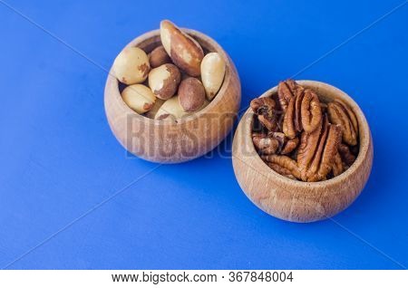 Pekan And Brazil Nuts On Blue Background. Healthy Food