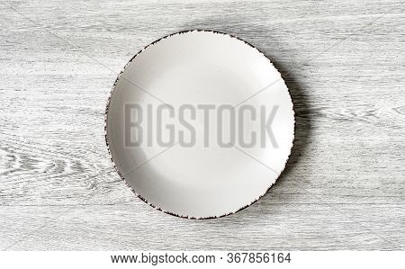 Plate On A Wooden Background Close-up. The View From The Top.