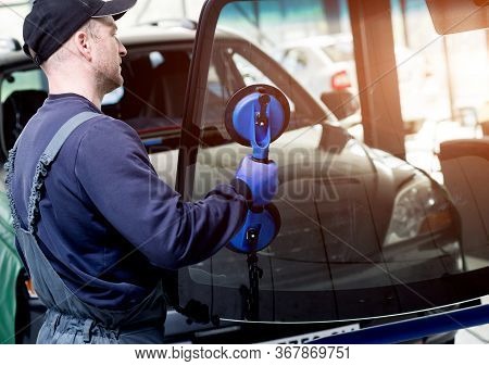 Automobile Special Workers Replacing Windscreen Of A Car In Auto Service