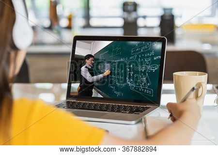 Rear View Of Asian Student Learning With Teacher Over The Physics Formular In Thai Laguage On Black 