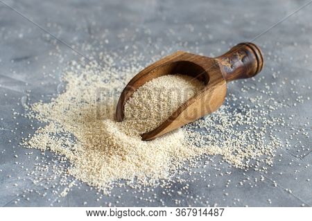 Raw Uncooked Fonio Seeds With A Spoon On Grey Background Close Up