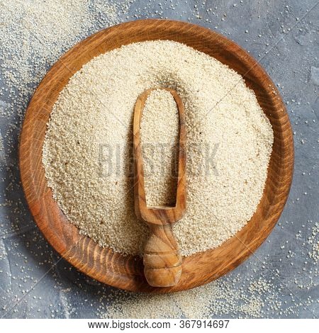 Raw Uncooked Fonio Seeds With A Spoon On A Plate On Grey Background Top View