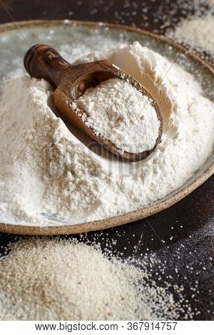 Raw Fonio Flour And Seeds With A Spoon On Dark Background Close Up. Alternative Flour