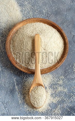 Raw Uncooked Fonio Seeds With A Spoon On A Plate On Grey Background Close Up