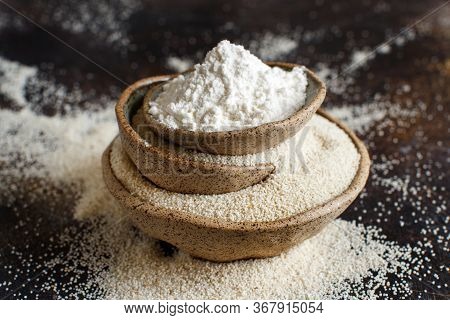 Raw Fonio Flour And Seeds In Bowls On Dark Background Close Up. Alternative Flour