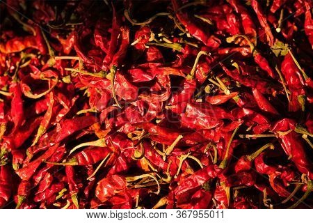 Dried dry red spicy chili peppers pile at asian market close up texture background. Sardar Market, Jodhpur, Rajasthan, India