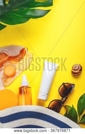Sunprotection Objects. Hat With Sun Glasses And Protection Cream Spf Top On Bright Yellow Background