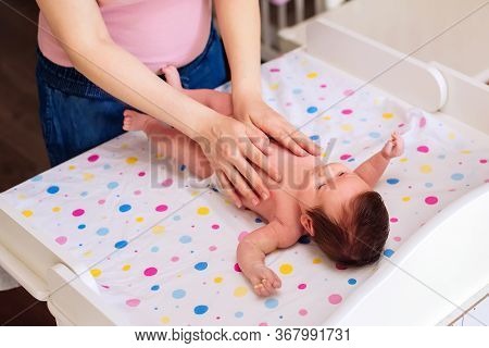 Mother Or Nanny Massaging Belly Of Infant Child At Home. Closeup Photo: Female Hands Massaging Stoma