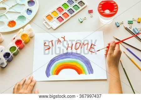 Girl Painting Rainbow On Paper During Covid-19 Quarantine At Home. Stay Home