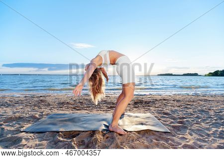 Young Woman Practicing Yoga Exercises .standing Backbend. Backbe