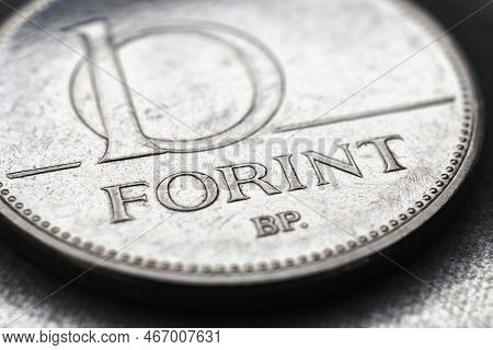 Hungarian Coin Of 10 Forints Lies On Textured Surface Close-up. Money Of Hungary. News About Economy