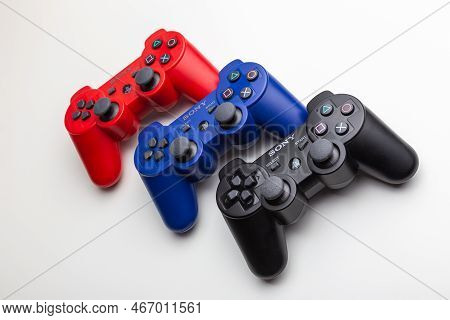 Multicolored Wireless Sony Playstation Controllers On A White Background