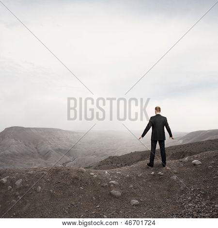 businessman standing alone in the desert