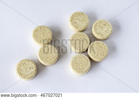 Supplements With Chewable Tablets Dgl Liquorice Root. Round Puck Tablets Of Beige Color With Dark Dr