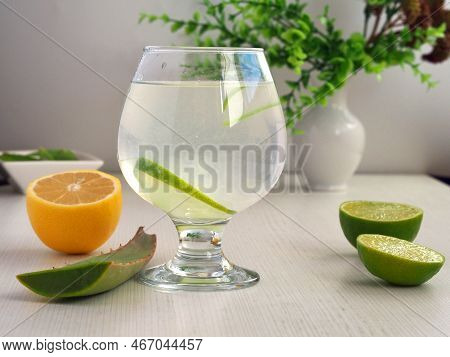 Detox Water Of Aloe Vera And Lemon Juice. A Glass Of Healthy Drink And Slices Of Lime And Sabila On 