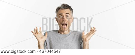 Close-up Of Scared Middle-aged Man, Looking Startled, Jumping And Screaming Frightened, Standing Amb