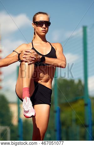 Young Woman Runner Warming Up At The Racetrack. Fit Runner Workout, Stretch Her Muscle And Warming U