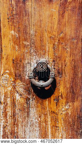 Antique Cast Iron Door Knob Knocker Round Shape With Floral Elements On The Background Of An Old Bro