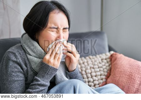 Close Up Of Young Korean Woman Staying At Home With Cold, Sneezing In Napking, Has Runny Nose, Conce