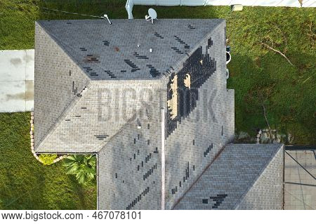 Damaged House Roof With Missing Shingles After Hurricane Ian In Florida. Consequences Of Natural Dis