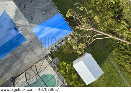 Hurricane Ian Damaged House Rooftop Covered With Protective Plastic Tarp Against Rain Water Leaking 