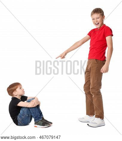 Boy Laughing And Pointing At Upset Kid On White Background. Children's Bullying