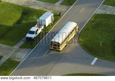 Top View Of Classical American Yellow School Bus Driving On Rural Town Street For Picking Up Kids Fo