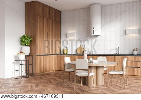 Corner View On Bright Kitchen Room Interior With White Tile Wall, Hardwood Floor, Sink, Dining Table