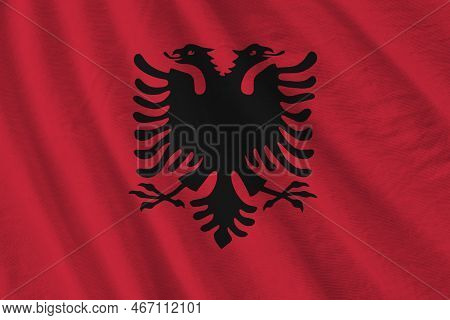 Albania Flag With Big Folds Waving Close Up Under The Studio Light Indoors. The Official Symbols And