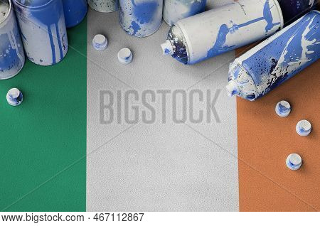 Ireland Flag And Few Used Aerosol Spray Cans For Graffiti Painting. Street Art Culture Concept, Vand