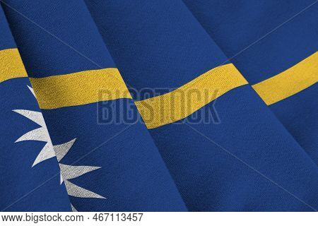 Nauru Flag With Big Folds Waving Close Up Under The Studio Light Indoors. The Official Symbols And C