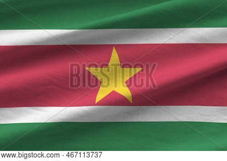 Suriname Flag With Big Folds Waving Close Up Under The Studio Light Indoors. The Official Symbols An