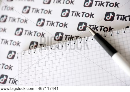 Ternopil, Ukraine - May 2, 2022: Notepad With Pen And Many Tiktok Logo Printed On Paper. Tiktok Or D