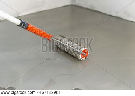 Needle Roller For Self-leveling Floors. Leveling The Floors With A Cement Mixture.