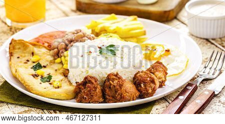 Plate Of Rice And Beans Typical Of Brazil, Fried Sausage, Fried Egg, Chopped Vegetables And Salad, B