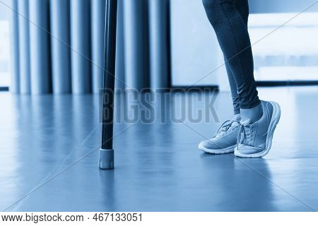 Legs Of Young Fit Woman Doing Exercise With Bodybar In Gym