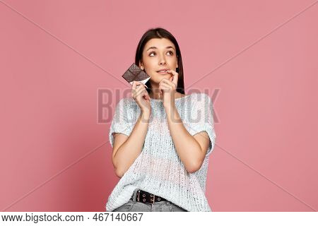 Young Woman In Sweater Holding Chocolate Bar