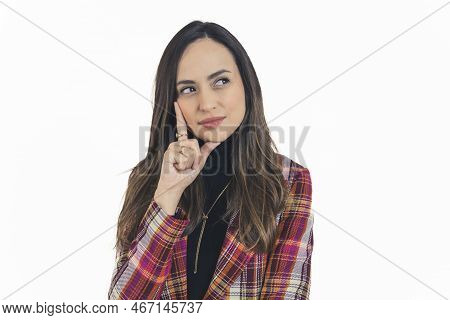 Portrait Of Young Latin American Woman Facing Camera Looking To The Side Holding Fingers To Face In 