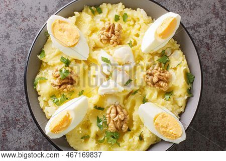 Delicious Mashed Potatoes With Salted Cod And Garlic Served With Walnuts And Boiled Eggs Close-up In
