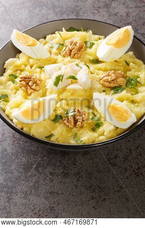 Spanish Cuisine Mashed Potatoes With Cod And Garlic Served With Walnuts And Boiled Eggs Close-up In 